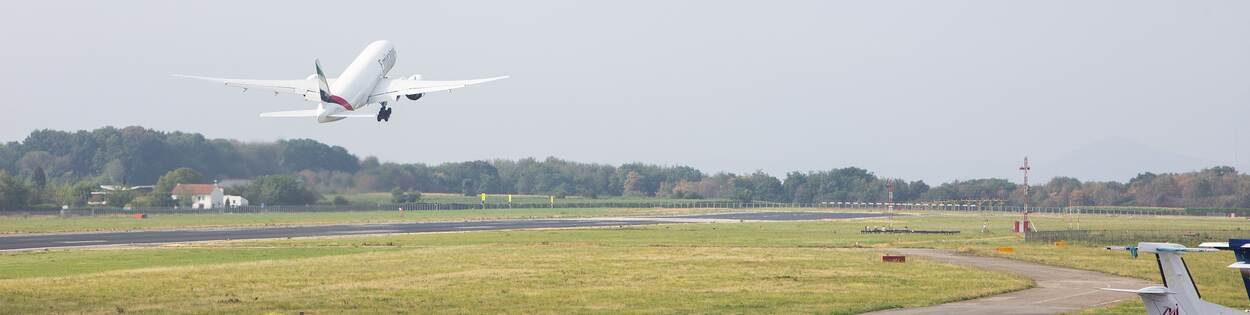 Vliegtuig stijgt op vanaf startbaan Maastricht Aachen Airport