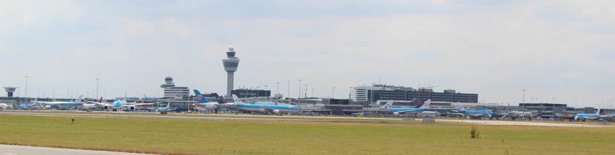 Luchthaven Schiphol met vliegtuigen en verkeerstoren