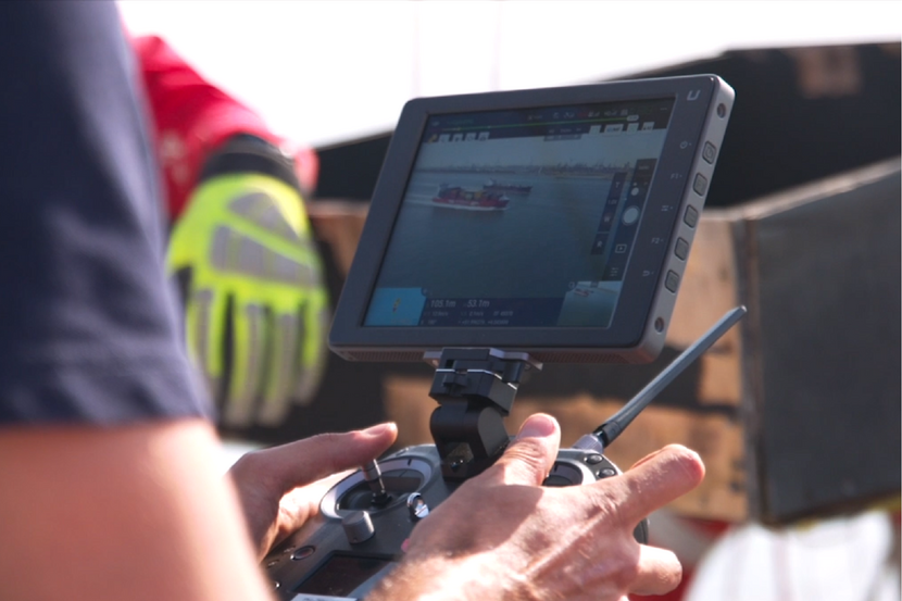 Controler (besturingsinstrument) van drone die binnenvaartschip filmt.