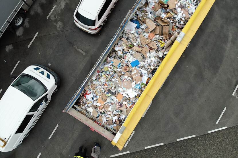 Drone-beelden van bovenaf in open transportcontainer met afvalstoffen papier en karton.