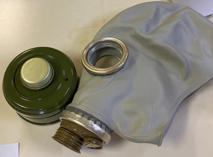Gasmasker van rubber met opschroefbare ronde bus die de ingeademde lucht filtert.