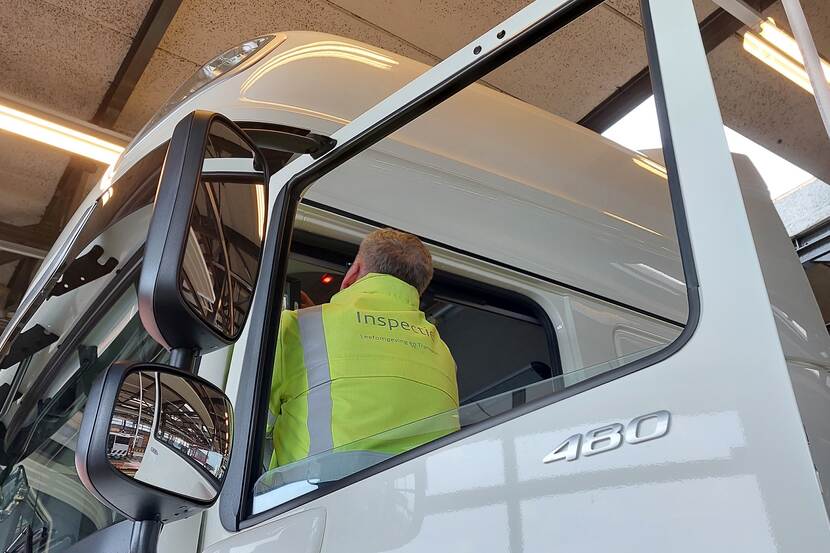 Inspecteur controleert in de cabine van een internationale vrachtwagen.
