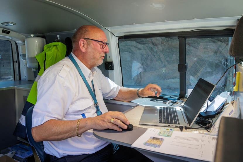 John Berkenbosch is inspecteur Goederenvervoer en zit achterin een inspectie bus. Hier bekijkt hij gegevens op een laptop.